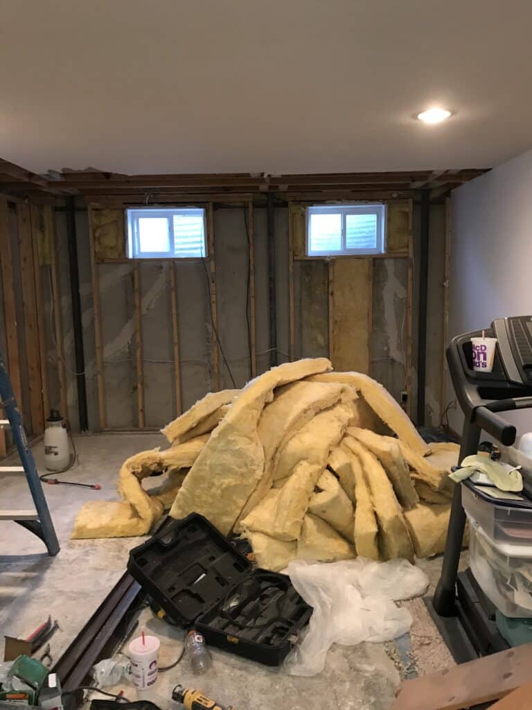 A pile of fiberglass insulation sits in a room waiting to be installed.